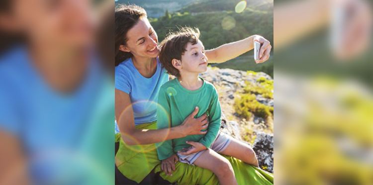 Okładka Raportu Zintegrowanego Orange Polska 2019 - matka z synem robią sobie zdjęcie