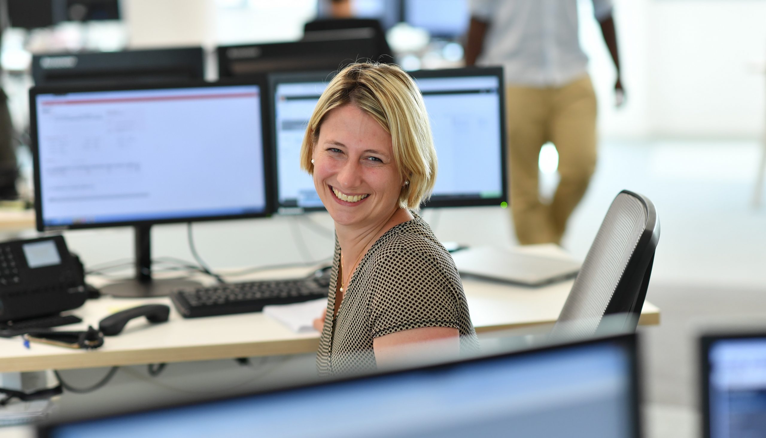 uśmiechająca się kobieta za biurkiem